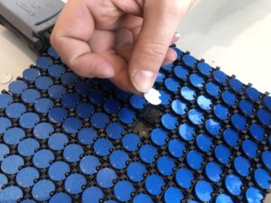 A close-up of the two-sided flip dots used in the installation, showing blue and white circular discs arranged in a grid.